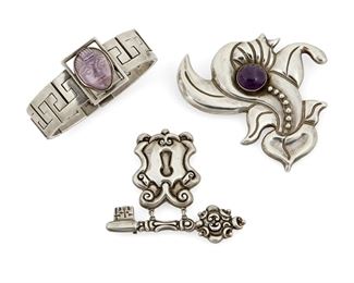 1278
A Mixed Group Of Mexican Silver Jewelry
Three works:

Two Parra silver brooches
Horacio de la Parra (b. 20th century)
Circa 1940; Mexico City, Mexico
Each stamped: Parra / Mexico; Variously stamped: Silver / HNO5 / Sterling
Comprising a stylized floral brooch with set amethyst cabochon (3" H x 3.25" W) and a brooch of a key suspending a lock (2.5" H x 3" W), 2 pieces

A bracelet designed with geometric hook shaped links centering a carved set amethyst face
Stamped with conjoined FRE; Further stamped: Hecho en Mexico / 388 [indistinct]
7" L x 1.25" H

3 pieces total
172.6 grams gross
Estimate: $400 - $600