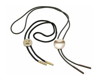1280
Two Modernist Bolo Ties
Mid/Late 20th century
One stamped: RA / 925 / Mexico
Each centering a disk designed with geometric motifs in layers of mixed materials, one set onto a rubberized tie terminating in spring tips (Pendant: 1.5" Dia.; Tie: 21.5" L) and one with a braided cord (Pendant: 1.125" Dia.; Tie: 17" L), 2 pieces
Estimate: $200 - $300