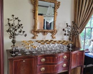 Antique gilt ornate wall mirror hand painted scene, gold rimmed goblets, American Masterpiece Collection Hickory White Sideboard, Candelabras
