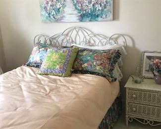 Iron bed, pillows, linens, wicker nightstand & picture
