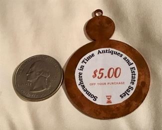 This is the backside of the brass token.  We will hide five tokens throughout the house.  They are good for 5.00 off your purchase! Turn it in to the cashier for your $5.00 credit 