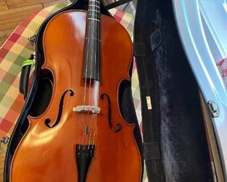 Cello with extra strings and a rolling carry case.