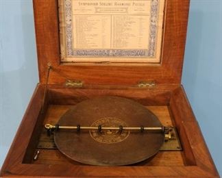 26 - Burl Walnut parlor table with Symphonion music box, 11 in. T, 22 in. W, 19 in. D.