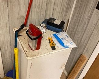 Cute little cabinet filled with tools.