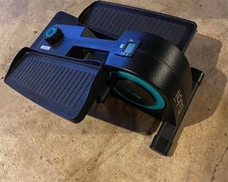 Cubii exercise machine with books and other items.