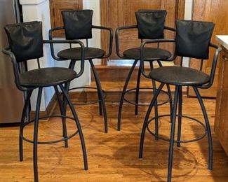 Set of Four Counter Height Swivel Stools. There is some light wear on several seats but all are in otherwise great shape. Each measures 17” in diameter, 28” high to the seat and 41” high to the chair back.