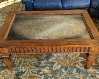 Large and Gorgeous Glass Topped Wood Coffee Table. It features a  pretty metallic design under the glass.  

There are some light scratches on the glass. Measures 31.5” x 45.5” 19” high