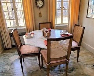 Beautiful hexagonal shaped marble table on painted carved pedestal base Set of four caned side chairs in very nice condition