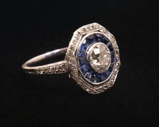 Lot 106  |  ANTIQUE DIAMOND & SAPPHIRE PLATINUM COCKTAIL RING  |  Having a central approximately 0.67ct European brilliant cut diamond (5.65 - 5.60 x 3.52mm) within concentric circles of sapphires and diamonds; size 4, 2.8g