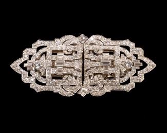 Lot 107  |  ART DECO DIAMOND DOUBLE CLIP BROOCH  |  Designed as matching platinum openwork Art Deco motif dress clips, each mounting an approximately 1/4 carat old European brilliant cut diamond, a 1/4 carat baguette diamond, seven .10ct baguettes, and 100+ full cut diamonds (.03-.07ct), affixed to a (tested to) 14k white gold frame mounting two melee diamonds; total weight 31.1g, total carat weight approximately 12.4 carats
h. 1-1/4 w. 2-3/4 in.