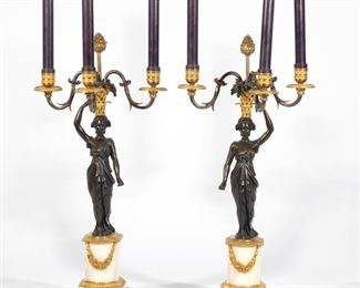 Lot 133  |  PAIR MID-19TH C. FRENCH EMPIRE BRONZE CANDELABRA  |  Circa mid-19th century, designed as a bronze female figure carrying a basket-form three-arm candelabra overhead, on a marble and ormolu base
h. 21-1/4 w. 10-1/4 d. 10 in.