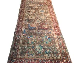 Lot 164  |  NORTHWEST PERSIAN LONG RUG  |  Early-mid 20th century, with arabesques of palmettes on a light brown field surrounded by meandering vine borders on a red ground
h. 13 ft. 5 in. w. 4 ft. 2 in.