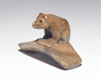 Lot 173  |  NATIVE AMERICAN EFFIGY PIPE - BEAR WITH FISH  |  Hopewell culture, Ohio, the platform pipe showing a standing bear above a fish, carved from a variegated grey pipestone, tag with Coe inventory number 5001
h. 2 w. 3-3/8 d. 2 in.