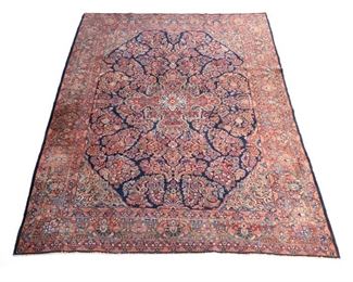 Lot 172  |  FINE PERSIAN KIRMAN / KASHAN CARPET, CIRCA 1930  |  Early 20th century, with a central medallion on an indigo field with gold spandrels, surrounded by a palmette border on a red ground
h. 11 ft. 7 in. w. 8 ft. 8 in.