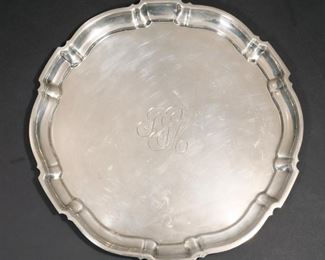 Lot 204  |  POOLE CHIPPENDALE STERLING SILVER TRAY  |  Round tray with shaped scalloped edge, the center with stylized monogram, marked on the underside, "Sterling by Poole / 100 / Chippendale"; 24 ozt dia. 11-3/4 in.