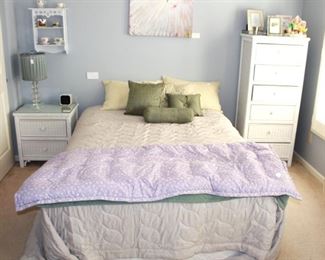 Bedroom is full of white wicker furniture and fun wall art and decor.