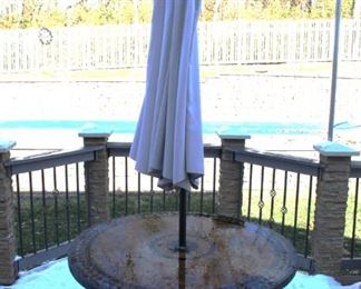 Round patio table with four chairs and umbrella.