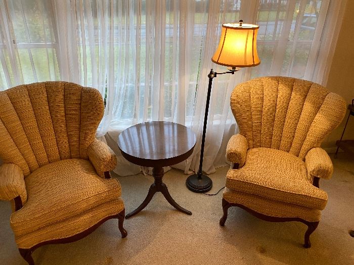Pair of absolutely phenomenal chairs accented by cute round mahogany table and classy lamp.