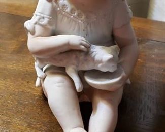 Bisque antique baby dolls with flat bottoms called piano babies.  This one is holding a cat.several pieces in various poses with beautiful painted features. Very special!