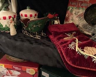 Dinnerware in original box , Christmas stockings, cake server, vinyl tablecloths, sleigh 