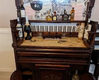 100+ year old pump organ. Bar surface and vertical backbar are covered in decoupage  1960 & 70s sheet music and photos of famous artists