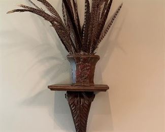 One of a pair of sconces and decorative pot with pheasant feathers.