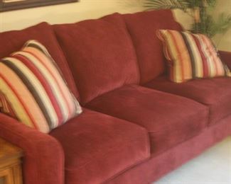 Three seat red fabric sofa.