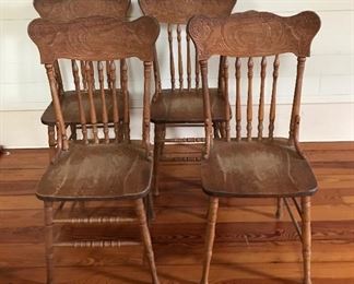 Four antique press back solid oak chairs 