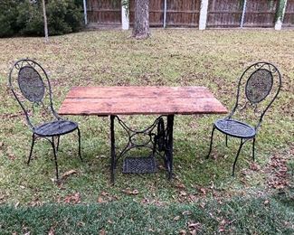 Handmade outdoor table with antique sewing machine base, wrought iron chairs 