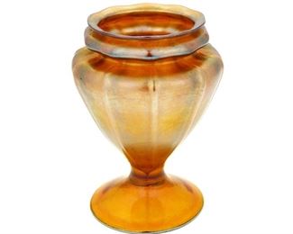 4101
Louis Comfort Tiffany
1848-1933
A Favrile Glass Vase, 1919; New York, NY
Engraved signature: L.C. Tiffany - lm. Favrile / 1557-5033 N
The gold iridescent Favrile glass vase with ribbed, tapered body on a round foot
6.75" H x 5" Dia.
Estimate: $600 - $800