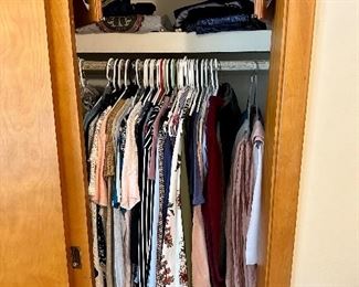 Two closets jammed with women's clothes.