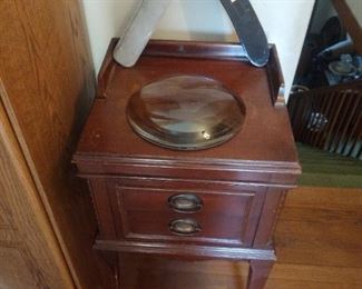 cute end table with a very large magnifying lense and very large novelty straight razor 