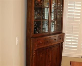 Presell @ $4998
American Corner Cupboard of Cherry wood primarily. Two six pane glazed doors over cabinet doors framed by full pilasters. Turned block and peg legs on casters. Circa 1840
Dimensions: 87”H x 40”W
Stock #013