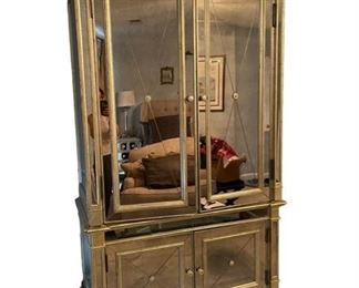 $2400     French Country Gold & Mirror Armoire DG145-7     Description:   This classic silhouette is transformed into a glamourous focal point with its mirrored surface, glimmering silver leaf trim and Visage finish, a patina of silver greige with amber glaze. Shelves or open for a TV behind two upper doors, and two bottom doors.
Condition: Very good
Dimensions: 49 x 26 x 87"H
Local pick up Rockville, MD.  Located on the second floor.  Contact us for shipper suggestions.    https://goodbyhello.com/products/gold-mirror-armoire-dg145-7?_pos=3&_sid=393e46d62&_ss=r