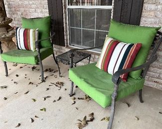 green cushioned patio chairs and side table