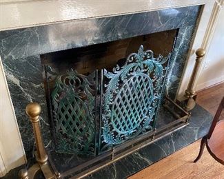 Stately art deco andirons, super classy fireplace rail, and ornate fire screen make this one of the coolest fireplaces I have seen.