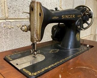 Vintage Singer sewing machine in cabinet with foot pedal