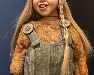 Zwergnase Doll Benedetta designed by Nicole Marshollek. An amazing life like doll! Be sure to see all the photos to view the amazing detail on this doll! She measures 21" h
Beautiful Benedetta has long blonde hair with one side featuring a braid and a scarf over. She wears a brown knitted jumper underneath a gray pinafore dress and on he feet, Benedetta wears brown real leather lace up boots.
Benedetta was limited to 250 pieces.