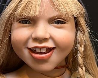 Zwergnase Doll Benedetta designed by Nicole Marshollek. An amazing life like doll! Be sure to see all the photos to view the amazing detail on this doll! She measures 21" h
Beautiful Benedetta has long blonde hair with one side featuring a braid and a scarf over. She wears a brown knitted jumper underneath a gray pinafore dress and on he feet, Benedetta wears brown real leather lace up boots.
Benedetta was limited to 250 pieces.