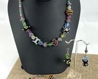 Colorful Beaded Jewelry Ensemble. Includes a matching set including a necklace, bracelet and pair of earrings.
The necklace measures 16.75”, the bracelet measuring 8.25”. The earrings are marked sterling.