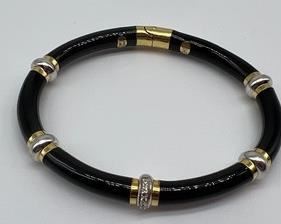 Black Enamel and 18k Diamond Bangle Bracelet by SOHO measuring about 2.75"
18k gold and enamel bangle bracelet. One row of full round brilliant cut diamonds pavé set in 18k gold. Incredibly durable and beautiful jet black enamel. The bracelet is sized 5.5mm. Stamped SOHO. Made in Italy.