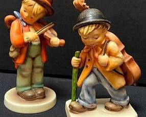 Two Hummels -
Hummel Figurine Little Fiddler with brown hat. Marked 2/0. Originally sculpted in 1935 by sculptor Arthur Moller in Germany. 5.75" tall. The Little Fiddler retired in 2003, never to be created again, the mold was destroyed.
Hummel Figurine Little Cellist stands 5.5" tall and was also designed by Arthur Moller in Germany.
These figurines do not come with a box. The winning bidder will need to bring their own packing materials and box to safety transport these adorable figurines.