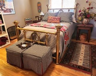 An antique brass bed and custom slip covered ottomans