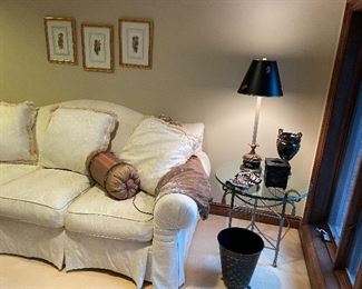 Camelback couch with 3 pillows by Hendredon, metal side table with glass top, buffet lamp with black shade and "bee" decor, black porcelain urn, and black hand-painted bathroom accessories