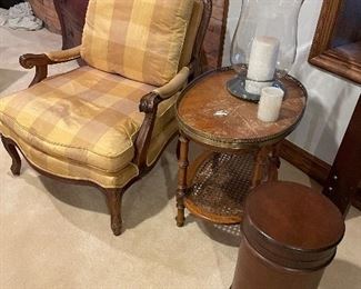 Silk upholstered armchair, side table with lower cane tier, leather canister, and glass hurricane candle holder