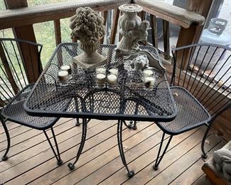 Metal cafe table with 2 chairs, cement yard art, and metal votive holder