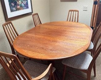 1970’s teak table with large leaf. “Eva” chairs, two have arms. 