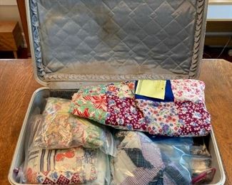 Vintage blue suitcase; variety of bagged quilting fabrics
