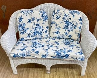 White wicker love seat with cushions