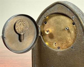 TIFFANY ZODIAC CLOCK  |  
Tiffany Studios New York desk clock with an arched bronze case, having zodiac designs replete with matching key in fitted holder on caseback door. - l. 4 1/4 x w. 2 x h. 5 1/4 in. (overall)